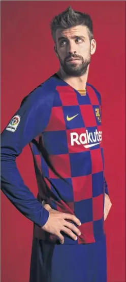  ??  ?? A CUADROS. Piqué, con la nueva camiseta a cuadros del Barça.