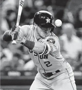  ?? Duane Burleson / Getty Images ?? The Astros’ Alex Bregman isn’t in as dire a situation as it appears as the ball has already hit his hip before deflecting upward in the seventh inning Tuesday night. Bregman stayed in the game.