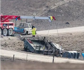  ?? MICHAEL BELL ?? A crane removes a water tanker from a ditch about 10 kilometres south of Burstall. James Hargrave, a volunteer firefighte­r from Alberta who was helping fight a raging grass fire this week, died in the crash.