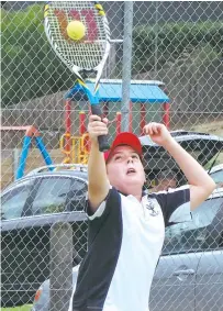  ??  ?? Angus Bridge serves during round 14 of Baw Baw junior tennis action at Warragul North.