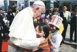  ??  ?? A girl embraces Francis as he arrives at Yangon Internatio­nal Airport yesterday.