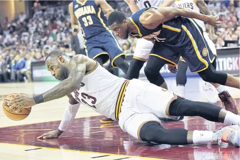  ?? USA TODAY SPORTS ?? Cavaliers forward LeBron James grabs a loose ball ahead of Pacers forward Thaddeus Young during the first half.