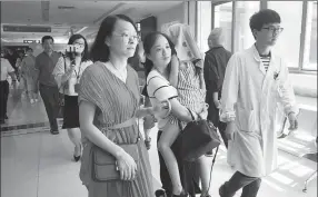  ?? SHEN ZHICHENG / FOR CHINA DAILY ?? A young survivor of the boat tragedy in Thailand is carried into Haining People’s Hospital in Haining, Zhejiang province, for a follow-up medical check. Six people from Haining who joined the tour group, including four who suffered minor injuries and...
