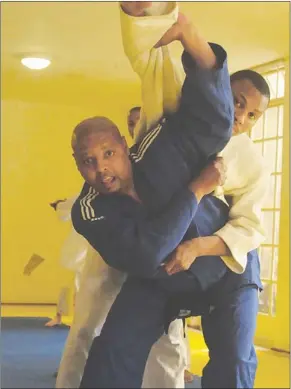  ??  ?? HARDER THAN IT LOOKS: Sondisa Magajana helps one of his pupils with a judo move