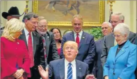  ??  ?? Donald Trump signs bills in the Roosevelt Room of the White House in Washington on Monday.