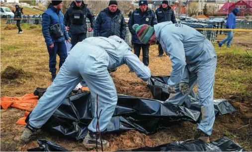  ?? EFE ?? Personal forense trabaja en la zona donde se encontró una fosa común detrás de una iglesia de Bucha (Ucrania)