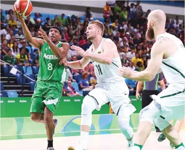  ??  ?? Nigeria's Josh Akognon is challenged by Lithuanian players during a basketball game at the 2016 Summer Olympics in Rio de Janeiro