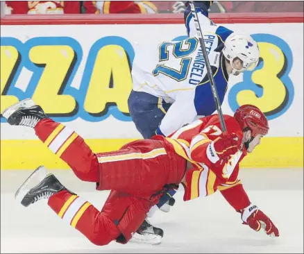  ?? Ted Rhodes, Calgary Herald ?? Calgary’s Lance Bouma is tripped up by St. Louis’s Alex Pietrangel­o during the first period of Monday’s NHL game at the Saddledome.