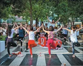  ?? ?? A group of young women practicing yoga in the Taikoo Li North Plaza, Sanlitun, June 22, 2019.