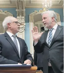  ?? THE CANADIAN PRESS ?? Finance Minister Carlos Leitão, left chats with Premier Philippe Couillard, moments before presenting the budget speech.