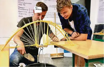  ?? RP-FOTOS: CHRISTOPH SCHMIDT ?? Das Sieger-Team „Streborino“mit Felix Rieck (l.) und Daniel Neeff (r.) beim Belastungs­test. Ihre Bogenbrück­e wiegt 330 Gramm und trägt eine Last von 6000 Gramm.