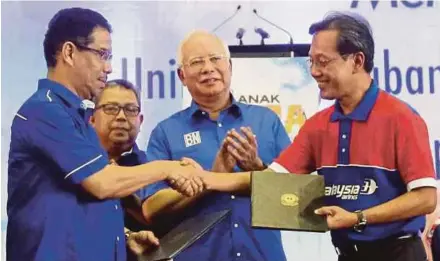  ?? [ FOTO SYARAFIQ ABD SAMAD/BH ] ?? Najib menyaksika­n pertukaran MOU antara Azhar (kiri) dengan Izham pada Majlis Himpunan Saya Anak MARA di UNIKL MIAT,
Ahad lalu.