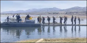  ?? PHOTO COURTESY OF THE LOS ANGELES COUNTY FIRE DEPARTMENT ?? Members of the Los Angeles County Urban Search and Rescue Team begin a dive operation Wednesday at Lake Palmdale in search of a missing boater. The team searched for more than seven hours before darkness halted the effort.