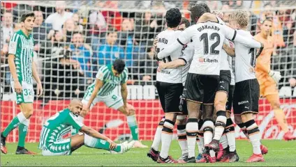  ?? FOTO: EFE ?? Los jugadores el Valencia, celebrando uno de los goles con los del Betis decepciona­dos al fondo