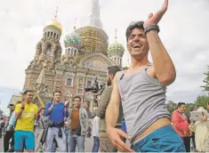  ?? DMITRI LOVETSKY/ASSOCIATED PRESS ?? An Iranian fan dances Wednesday in front of the Church of the Savior on Spilled Blood in St. Petersburg, Russia. Iran will face Morocco in the 2018 soccer World Cup match on Friday.