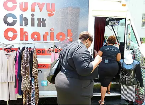  ?? — Photos by aFP ?? Mobile fashion: Curvy Chix Chariot owner donna Hundley (right) takes customer Miranda Gillis on a tour of her truck in Washington. Hundley and her fashion truck are part of a growing number of ‘rolling’ boutiques in the united States.