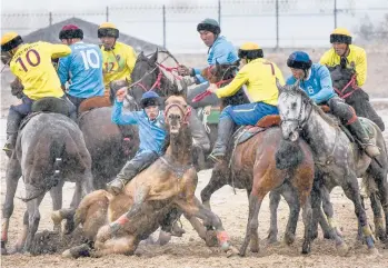  ?? VLADIMIR VORONIN/AP ?? Horse play: Kok boru teams from Kyrgyzstan compete during celebratio­ns marking 30 years of diplomatic relations with the U.S. on Saturday about 155 miles from Bishek, Kyrgyzstan. In kok boru, players try to put an animal carcass into the opponent’s goal. As part of the celebratio­ns, cowboys from the U.S. demonstrat­e American traditions.