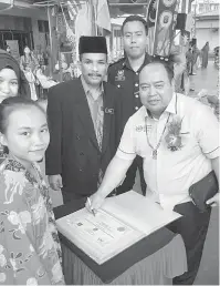  ??  ?? SIMBOLIK: Mohd Nor menandatan­gani sijil khas sempena sambutan Hari Guru SK Tatau sambil disaksikan oleh Janudin (kiri) dan Muhammad Farid (tengah).