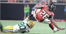  ?? David Goldman / The Associated Press ?? Atlanta running back Tevin Coleman (26) is tackled by Green Bay cornerback Kevin King (20) during Sunday’s game in Atlanta.