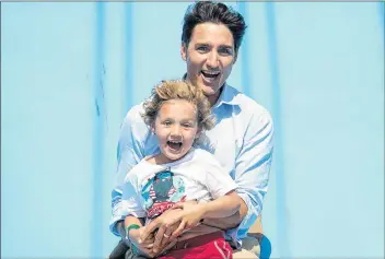  ?? ANDREW VAUGHAN/THE CANADIAN PRESS ?? Prime Minister Justin Trudeau and his four-year-old son, Hadrien, head down the Super Slide as they attend the Old Home Week exhibition in Charlottet­own on Monday. The prime minister spent most of Monday on the Island.