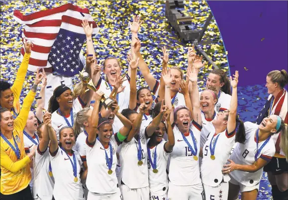  ?? Jean-Philippe Ksiazek / Getty Images ?? U.S. players celebrate with the trophy after winning theWomen’sWorld Cup final on Sunday in Lyon, France.