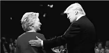  ?? PHOTO: REUTERS ?? FIRST POINT Democratic US presidenti­al nominee Hillary Clinton and her Republican counterpar­t, Donald Trump, greet each other at their first presidenti­al debate at Hofstra University in Hempstead, New York, on Monday. The latest opinion polls peg her...