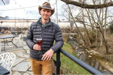  ?? STAFF PHOTO BY OLIVIA ROSS ?? Jay Martin stands on the patio at Flora de Mel on Thursday. The patio overlooks a waterway that is undergoing a runoff remediatio­n project by a nonprofit.