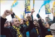  ?? Tolga Bozoglu
European Pressphoto Agency ?? SOCCER FANS rally outside an Istanbul court in support of a club official who is among those on trial.