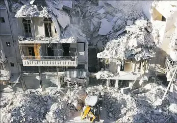  ??  ?? A tractor clears the rubble Saturday following airstrikes by Syrian govermnet forces in the rebel held neighborho­od of Tariq a-Bab in Aleppo.