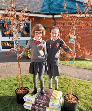  ?? ?? Pupils from St Edmund Campion with the trees that they have won by entering a competitio­n run by the Advertiser. Ref:134049-4