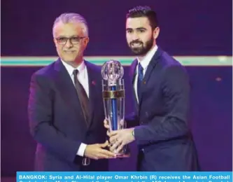  ?? — AFP ?? BANGKOK: Syria and Al-Hilal player Omar Khrbin (R) receives the Asian Football Confederat­ion Men’s Player of the Year award at the AFC Annual Awards in Bangkok yesterday.