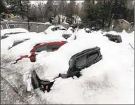  ?? Brian van der Brug Los Angeles Times ?? CARS ARE BURIED at a used-car lot as rain falls and snow melts in an area of the San Bernardino Mountains.