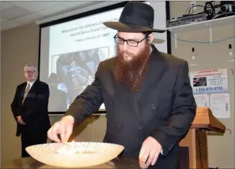  ?? ANDREA PEACOCK/The Okanagan Saturday ?? Rabbi Shmuly Hecht, with the Chabad Okanagan Centre for Jewish Life and Learning, lights a candle at the grand opening of the sacred space at Kelowna General Hospital on Friday.