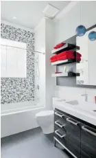  ??  ?? Left: Designed with children in mind to be fun and whimsical while still masculine and modern enough to grow with them into their older years, this main bathroom uses marble bubble tile on the back wall to create a focal point.