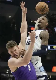  ?? (AP/Morry Gash) ?? Ja Morant (12) of the Memphis Grizzlies tries to dunk over Meyers Leonard of the Milwaukee Bucks during an April game in Milwaukee. With Morant suspended for the first 25 games of next season, the Grizzlies are concerned about their playoff chances.