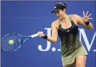  ?? Al Bello / Getty Images ?? Garbine Muguruza returns the ball against Andrea Petkovic during the second round at the U.S. Open on Tuesday.