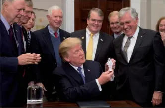  ?? SAUL LOEB / AGENCE FRANCE-PRESSE ?? US President Donald Trump holds up an astronaut toy alongside former US Senator and Apollo 17 Astronaut Jack Schmitt (right), after a signing ceremony for Space Policy Directive 1, with the aim of returning US astronauts to the surface of the moon, at...