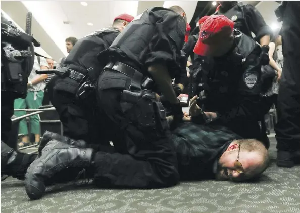  ?? JOHN KENNEY ?? A protester is subdued in the hearing room where the first day of the National Energy Board public hearings into the Energy East pipeline project were to have taken place. Montreal mayor Denis Coderre, an opponent of then pipeline project, left without...