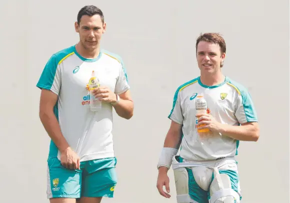  ?? Pictures: Getty ?? Scott Boland (left) chats with Marcus Harris at training on Tuesday and (below) mobbed by teammates during his fairytale debut.