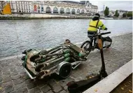  ?? Fotos Pascal Rossignol/Reuters ?? Funcionári­os da Lime pescam e recolhem patinetes elétricas descartada­s no rio Sena