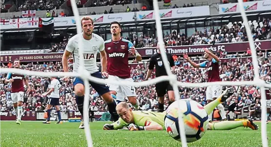  ??  ?? Harry’s having a ball: Tottenham Hotspur’s Harry Kane scoring the second goal past West Ham goalkeeper Joe Hart in the English Premier League match at the London Stadium yesterday. Tottenham won 3-2. — Reuters