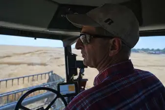  ??  ?? Ed Asfeld, of Colorado State University, runs a combine to cut wheat samples for the university to test on July 8 in Burlington.