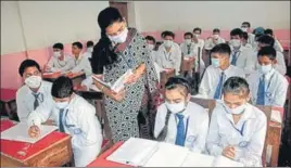  ?? MANOJ DHAKA/HT ?? Students of a school taking their classes wearing masks to protect themselves from pollution in Rohtak on Saturday.