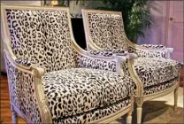  ?? Tribune News Service ?? These very traditiona­l Highland House wood frame arm chairs get an exotic facelift with the addition of black and white leopard upholstery.