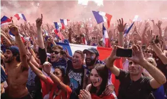  ??  ?? France supporters following the telecast in an open park celebratin­g one of the goals