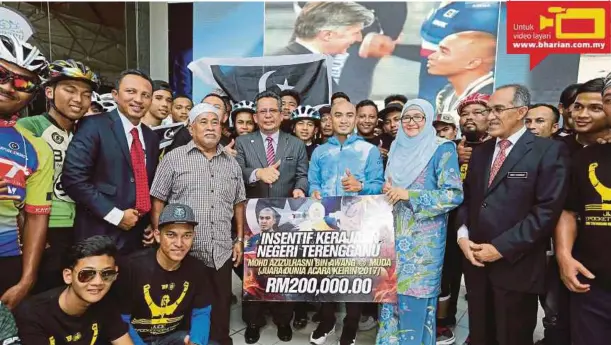  ?? [FOTO ROZAINAH ZAKARIA/BH] ?? Ahmad Razif menyampaik­an replika cek sebagai insentif kerajaan Terengganu sempena meraikan kejayaan Azizulhasn­i di Wisma Darul Iman, Kuala Terengganu, semalam.