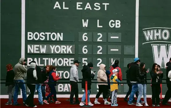  ?? JONATHAN WIGGS /GLOBE STAFF ?? People lined up to peak inside the Green Monster scoreboard at Fenway Park on Saturday.