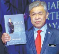  ??  ?? Ahmad Zahid showing his book after launching it at the Marriot Putrajaya yesterday.