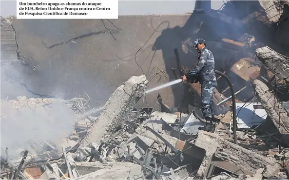  ??  ?? Um bombeiro apaga as chamas do ataque de EUA, Reino Unido e França contra o Centro de Pesquisa Científica de Damasco