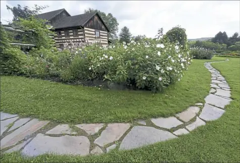  ?? Darrell Sapp photos/Post-Gazette ?? A walkway designed by students in Carnegie Mellon University professor John Folan's Urban Design Build Studio bends around a flowerbed to connect to the new SAMA - Ligonier Valley sculpture park.